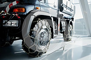 Jeep with snow chains parked indoors at the white tile on vehicle show