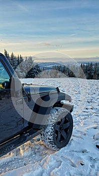 Jeep wrangler in the mountains at sunset. Snowy mountains 4x4