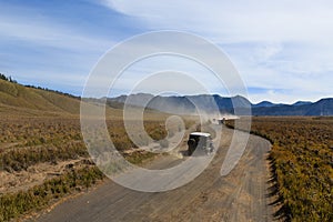 Jeeps pass through Bromo mountain savana photo