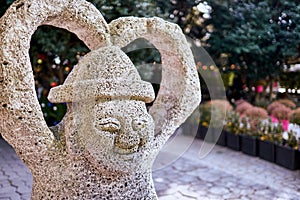 Jeju Island, South Korea : January 1, 2018 : Smiling harubang sculpture with its arms forming a heart shape at a maze theme park