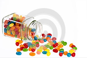 Jelly Beans candy spilled from glass jar isolated on white background