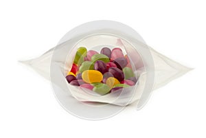 Jelly beans or sugar coated gummy candy inside a plastic bag. isolated. Shallow depth of field