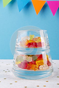 Jelly candy in a glass bowl on blue party background