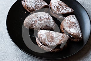 Jelly Filled Chocolate Cookies with Powdered Sugar and Cherry Jam.