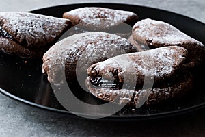 Jelly Filled Chocolate Cookies with Powdered Sugar and Cherry Jam.