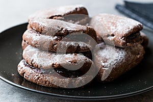 Jelly Filled Chocolate Cookies with Powdered Sugar and Cherry Jam.