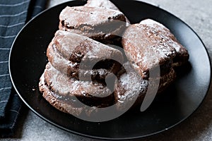 Jelly Filled Chocolate Cookies with Powdered Sugar and Cherry Jam.