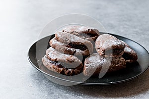 Jelly Filled Chocolate Cookies with Powdered Sugar and Cherry Jam.