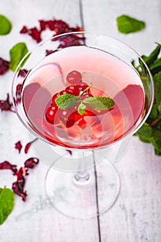 Jelly with red currant in martini glass on wooden background