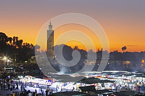 jemaa el Fna at sunset. The night is coming and the city life is starting in the market photo