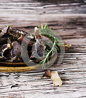 Jerked meat, cow, deer, wild beast or biltong in wooden bowls on a rustic table