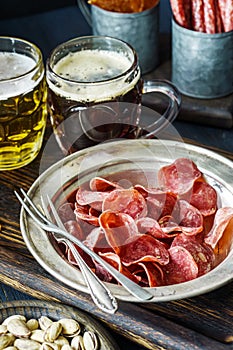 Jerky pork chips on vintage plate with beer on table