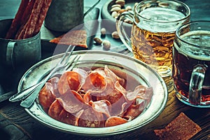 Jerky pork chips on vintage plate with beer on table