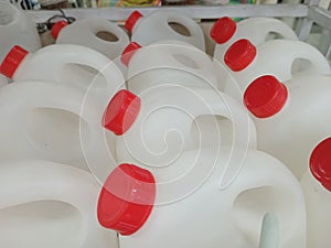 Jerry cans made from white plastic with red lids