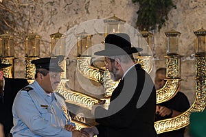 Chief Rabbi of Israel Rabbi David Lau lighting Hanukkah candles at the Western Wall next to Police Chief Roni Alshikh