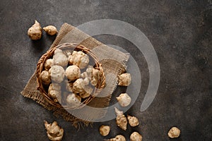 Jerusalem artichoke root, raw sunchokes on brown