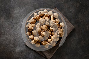 Jerusalem artichoke root, sunchokes on dark brown