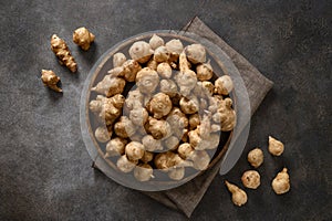 Jerusalem artichoke root, sunchokes on dark brown.