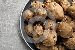 Jerusalem artichokes on light grey table, top view. Space for text