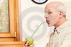 Jestful elder in kitchen, focused on apple