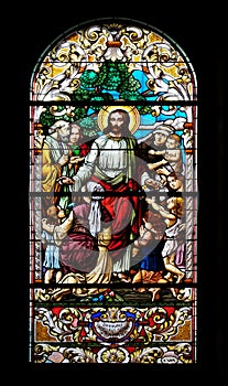 Jesus blesses mothers with children, stained glass window in the Saint John the Baptist church in Zagreb photo