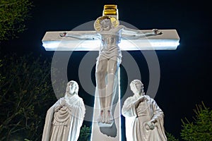 Jesus Christ on the cross in the dark of night. Religious background with copy space