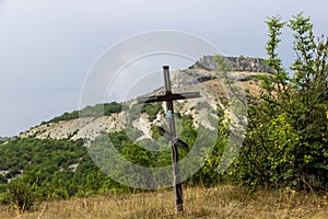 Jesus Christ cross. Easter, resurrection concept. Christian wooden cross on a background with dramatic lighting, colorful mountain