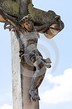 Jesus Christ on the cross old antique stone sculpture covered in moss, cemetery graveyard figure object closeup detail, nobody