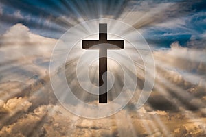 Jesus Christ cross on a sky with dramatic light, clouds, sunbeams. Easter, resurrection, risen Jesus concept