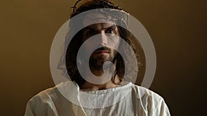 Jesus Christ in crown of thorns holding burning candle, resurrection symbol