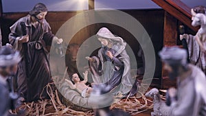 Jesus Christ Nativity scene with figurines in stable and light particles