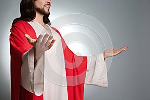 Jesus Christ with outstretched arms on grey background, closeup