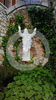 Jesus Christ with outstretched arms made of stone on the estate of the castle of Nancy and Patrick in Medjugorje.