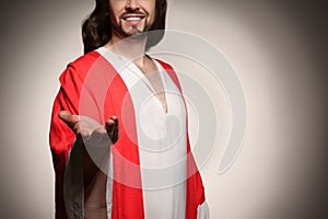 Jesus Christ reaching out his hand on beige background, closeup. Space for text