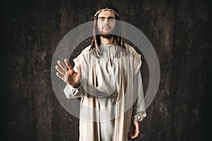 Jesus Christ reaching out his hand, peace symbol
