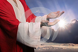 Jesus Christ reaching out his hands and praying against blue sky