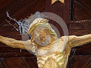 Jesus Christ sculpture on cross landmark with frosted fir needles