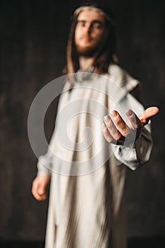 Jesus Christ in white robe reaching out his hand