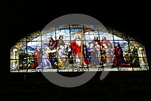 Jesus with the cross in stained glass window of cathedral church photo