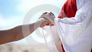 Jesus holding male hand to bless and heal Christian, religious miracle, closeup