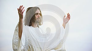 Jesus raising hands illuminated with light, resurrection and ascension of God