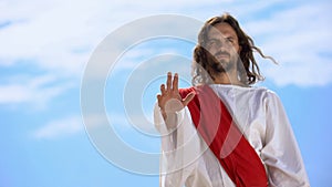 Jesus in robe stretching opened palm on camera, blessing and healing, template