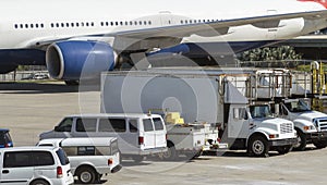 Jet aircraft on the apron with service vehicles photo