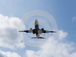 A jet airplane sillhouette as it flies overhead.