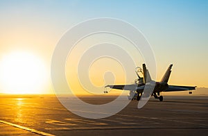 Jet fighter on an aircraft carrier deck against beautiful sunset sky . photo