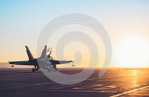 Jet fighter on an aircraft carrier deck against beautiful sunset sky . photo