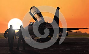 Jet fighter pilots silhoutte at sunset on military base airfield