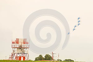 Jet fighters on a turn flies over an airfield with locators