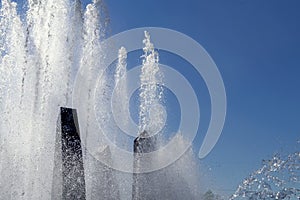 Jet fountain against the blue sky Water jet from a vertical fountain cut out against a blue sky