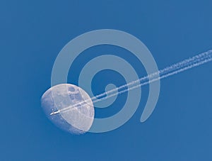 Jet plane on blue sky against moon